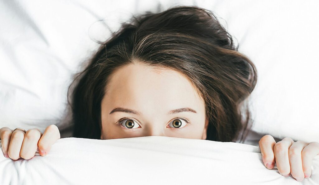 woman covering her face with blanket